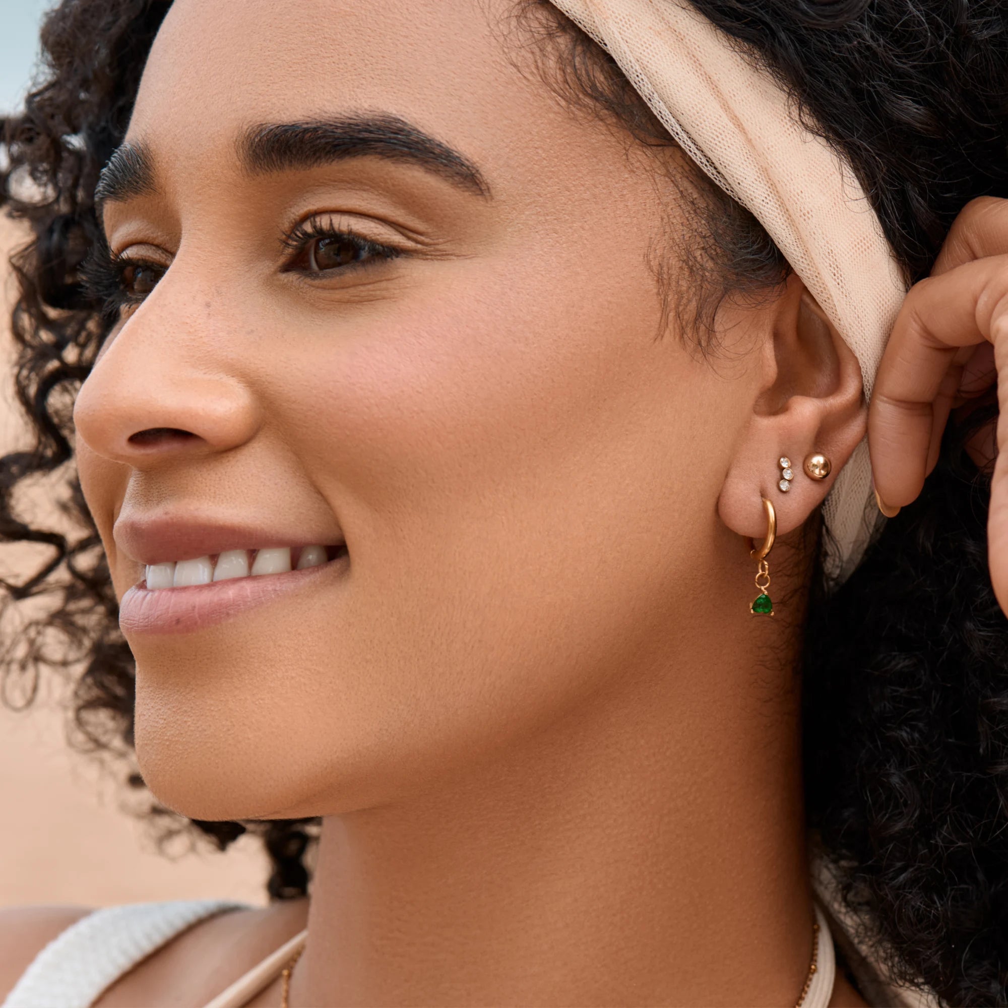 Close-up of a woman wearing earrings with a neutral background