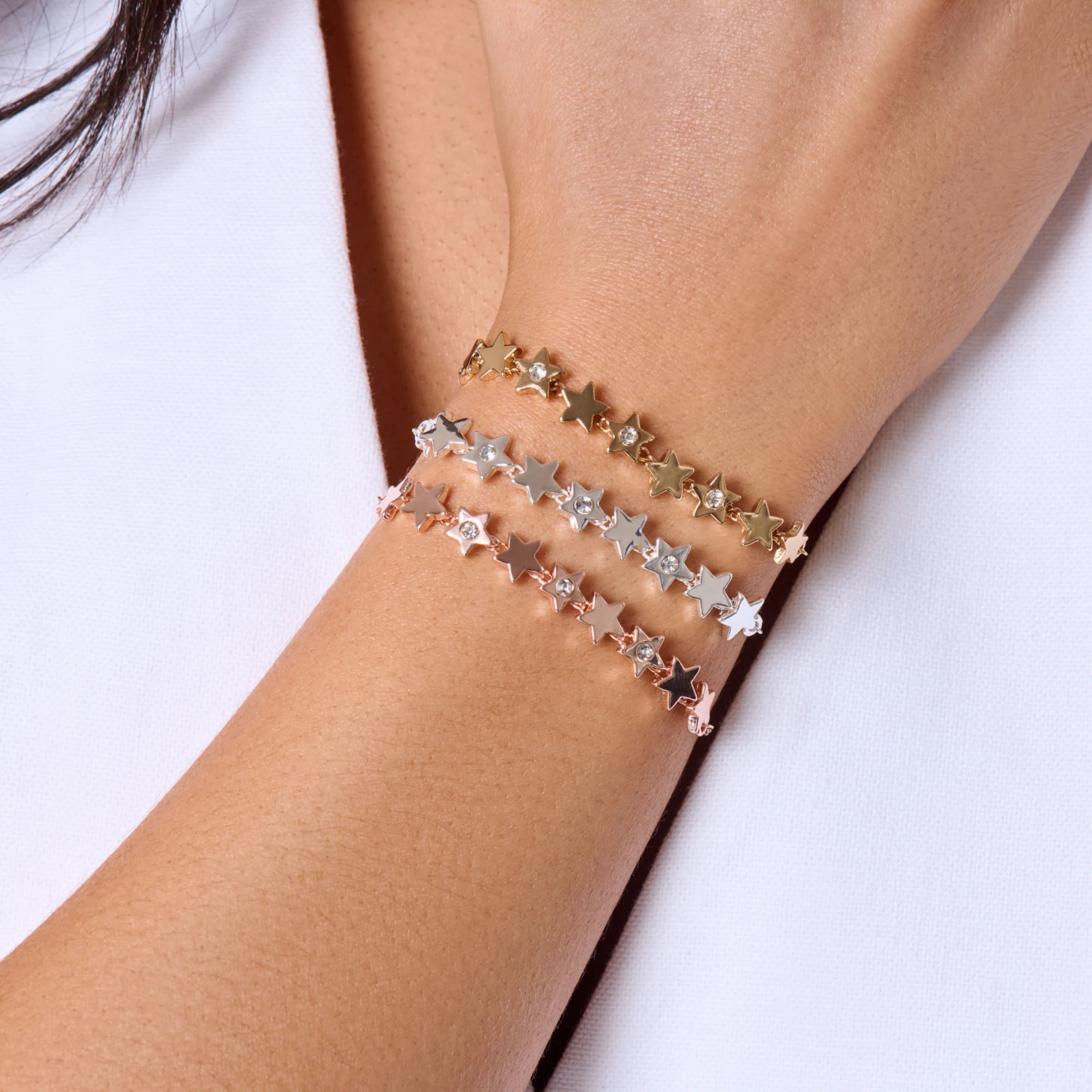 Star-shaped bracelet on a wrist with a white background