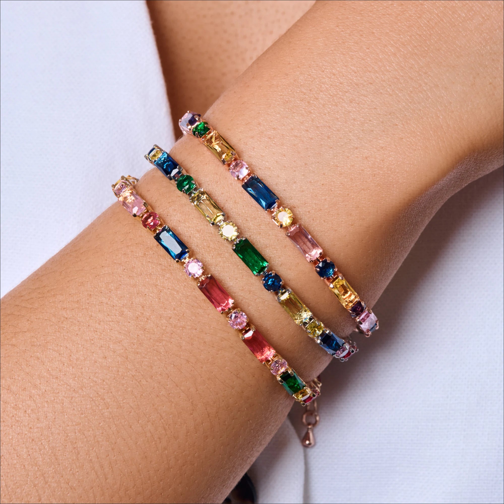 Multicolored beaded bracelet on a wrist against a white background